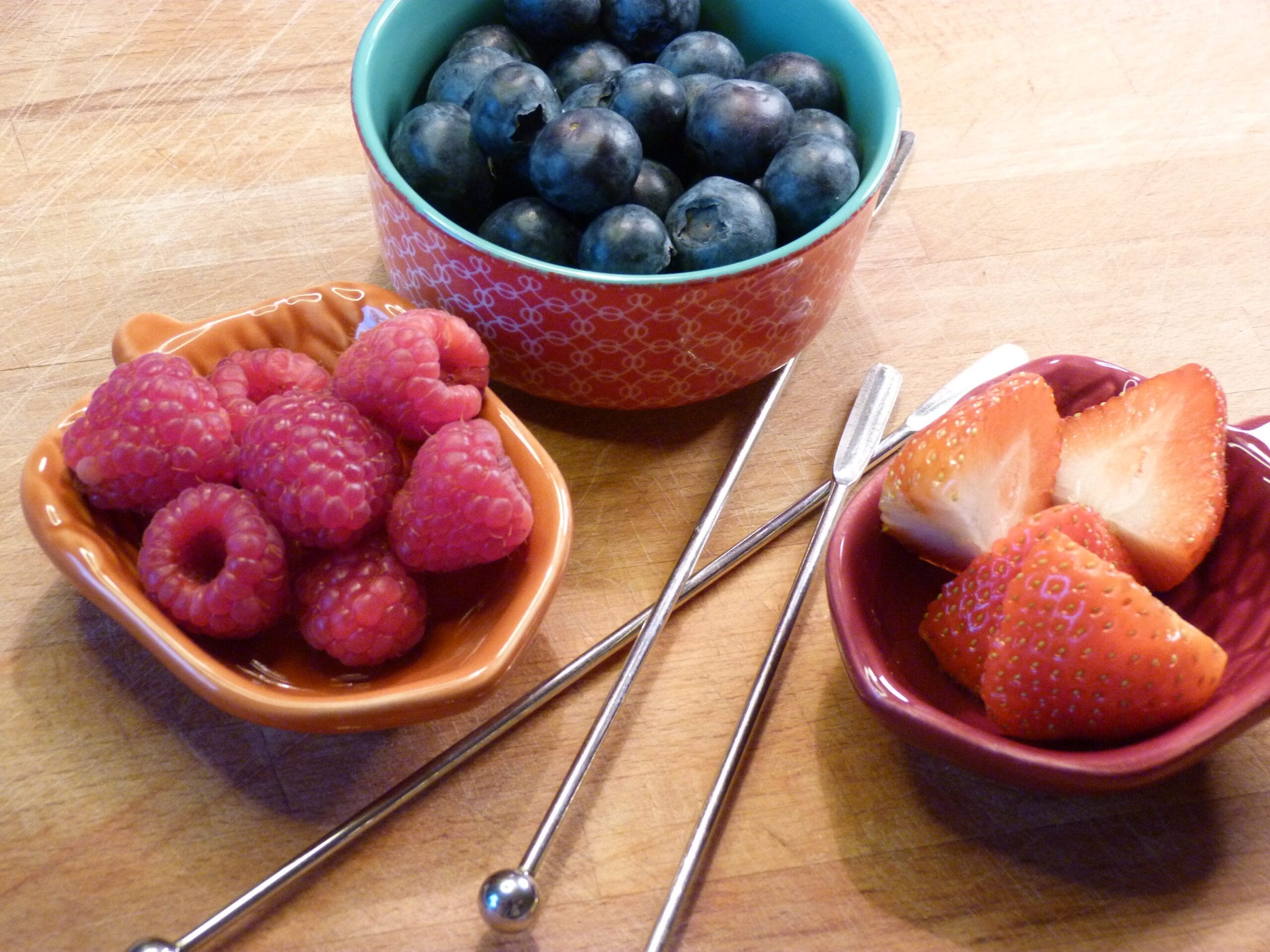 Rainbow fruit kebabs with ingredients lined up in colour order