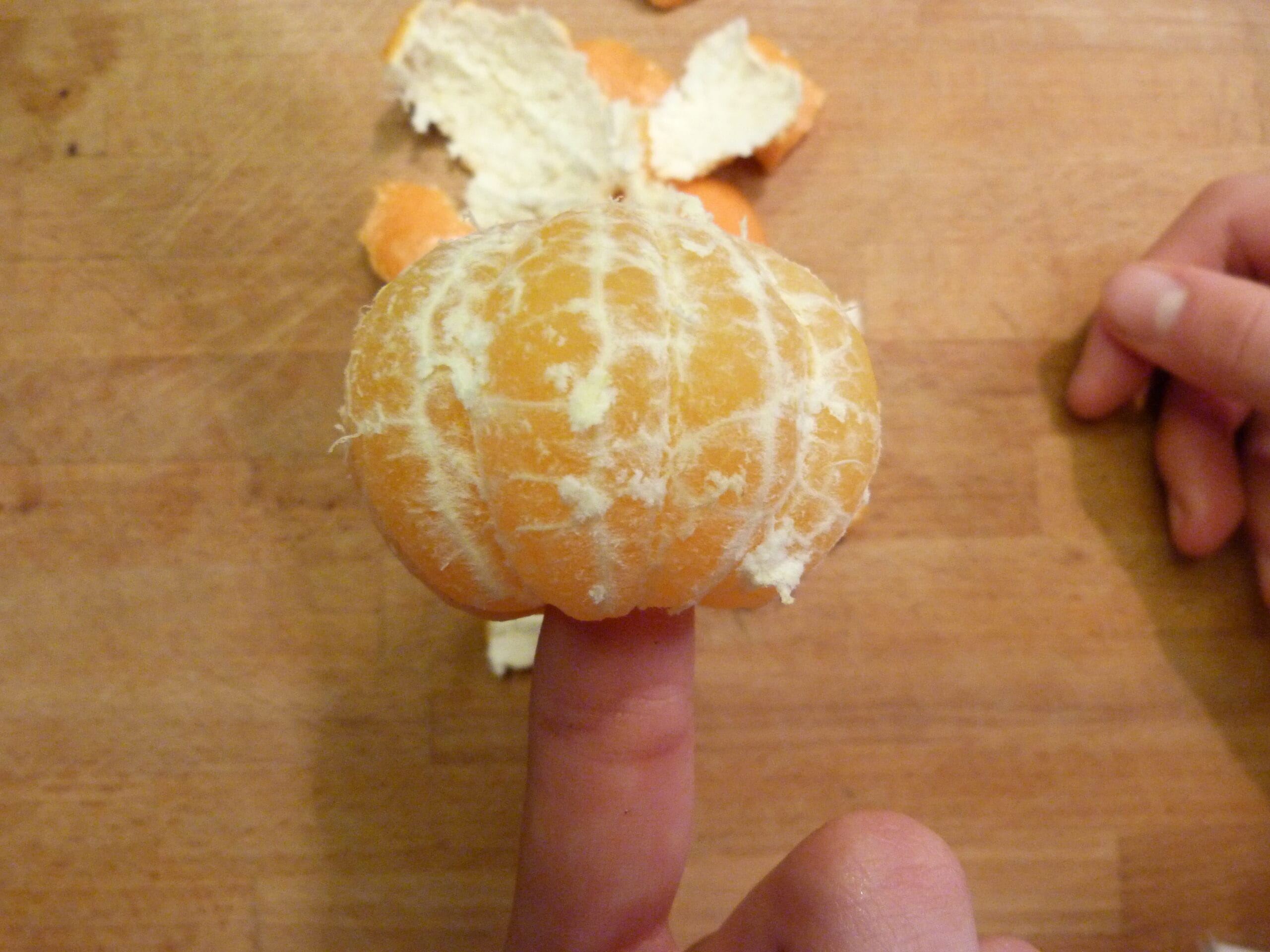 A child peeling an orange, practising fine motor skills
