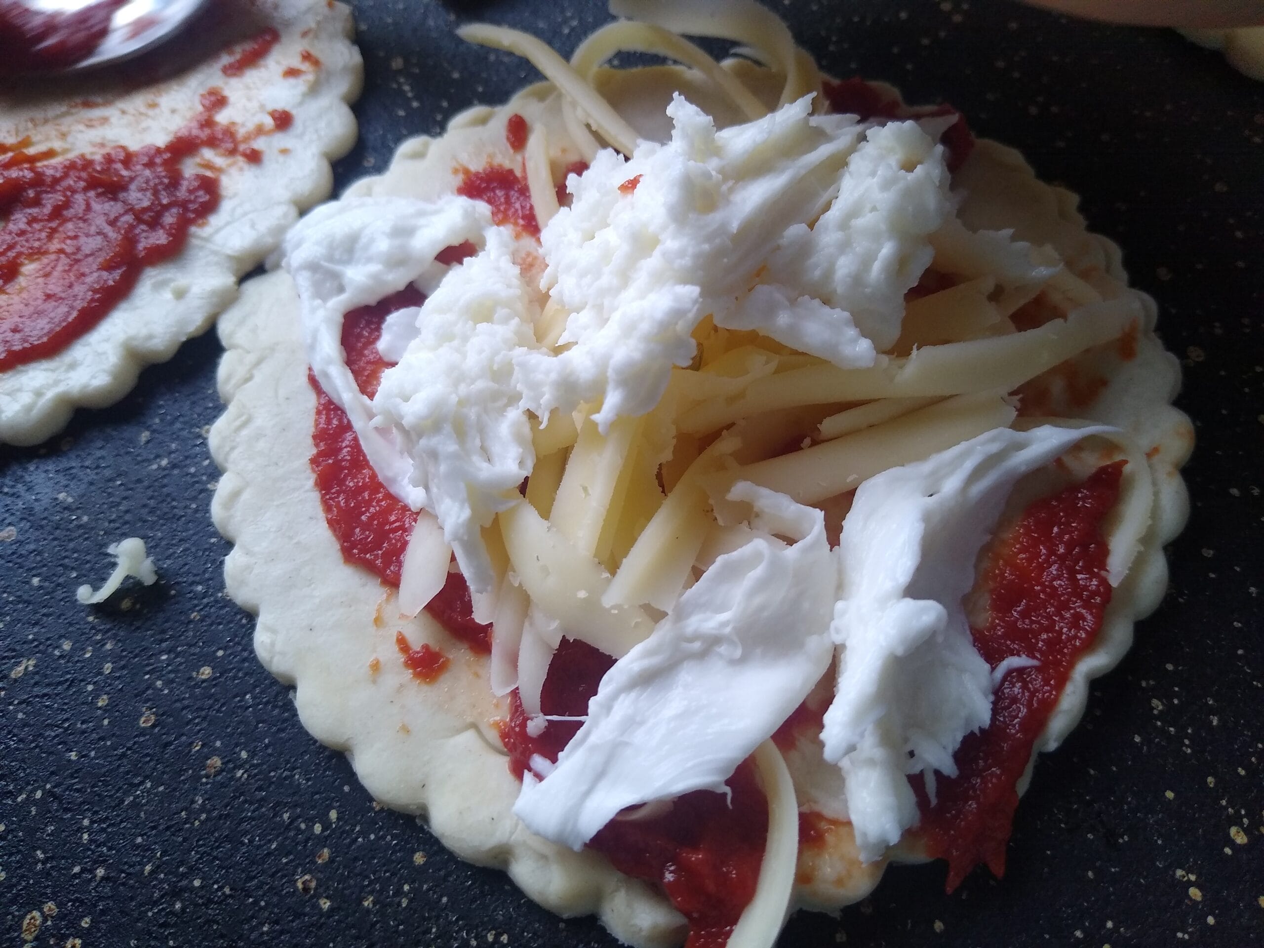 Children creating mini pizzas