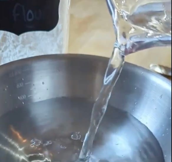 A child pouring liquid from one container to another